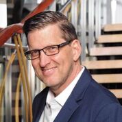 headshot of AtlasIED Vice President of Sales Michael Peveler wearing eyeglass smiling